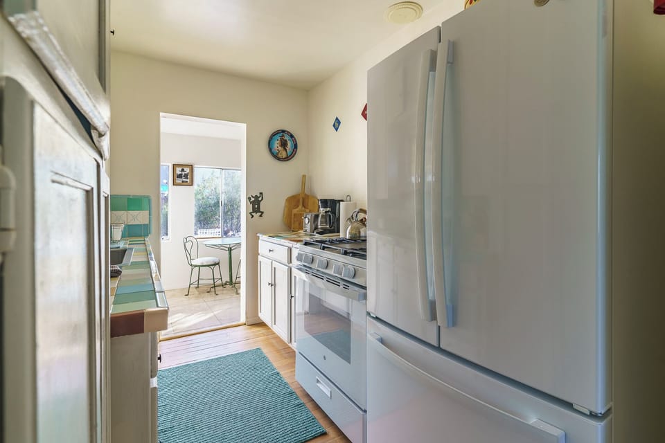 Galley kitchen with gas stove and full-size refrigerator
