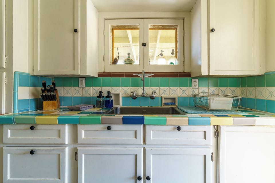 Kitchen sink with vintage tile and window above
