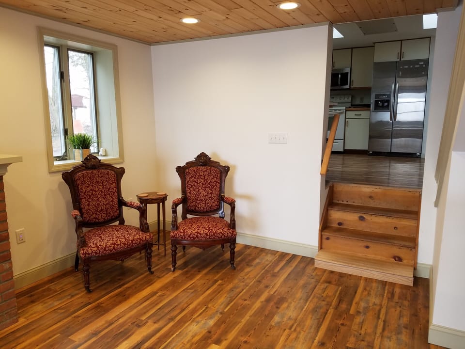 Stairs from the living room area up to the kitchen, full bath, and laundry room.