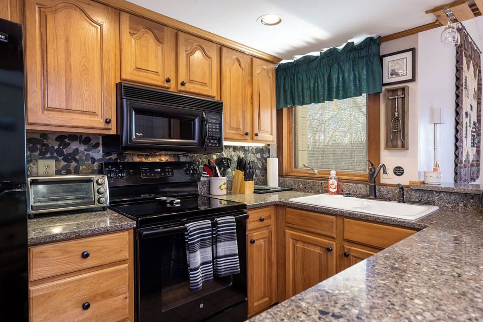 Kitchen with dishwasher, stocked with dishes, utensils, pots & pans, linens, etc