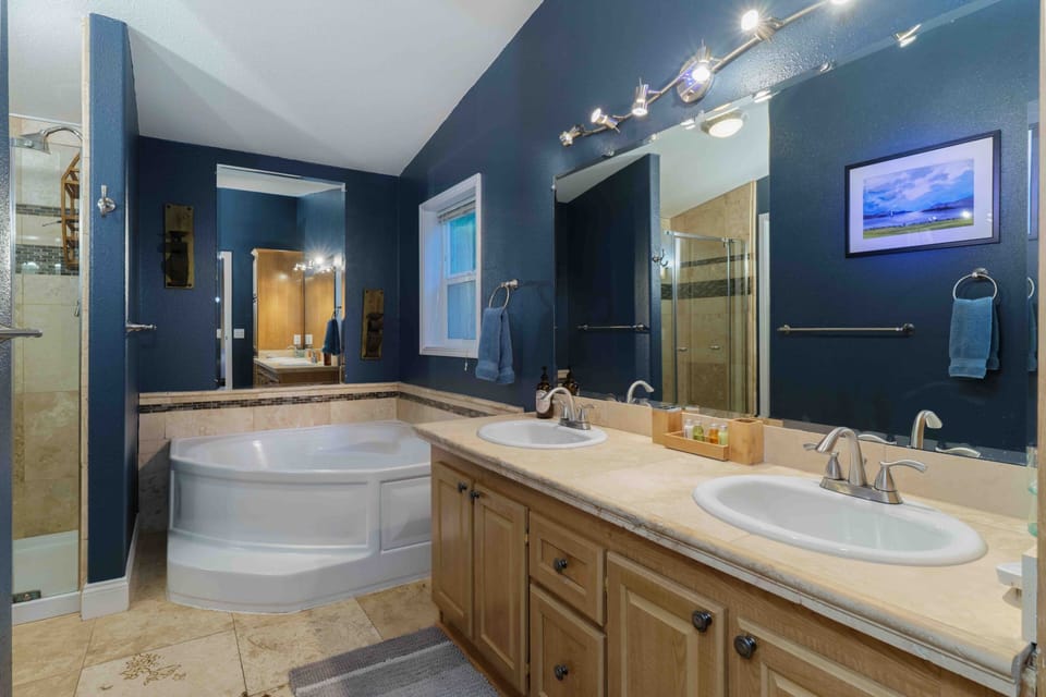 Updated Master Bathroom with Travertine Tile Floors and Vanity.