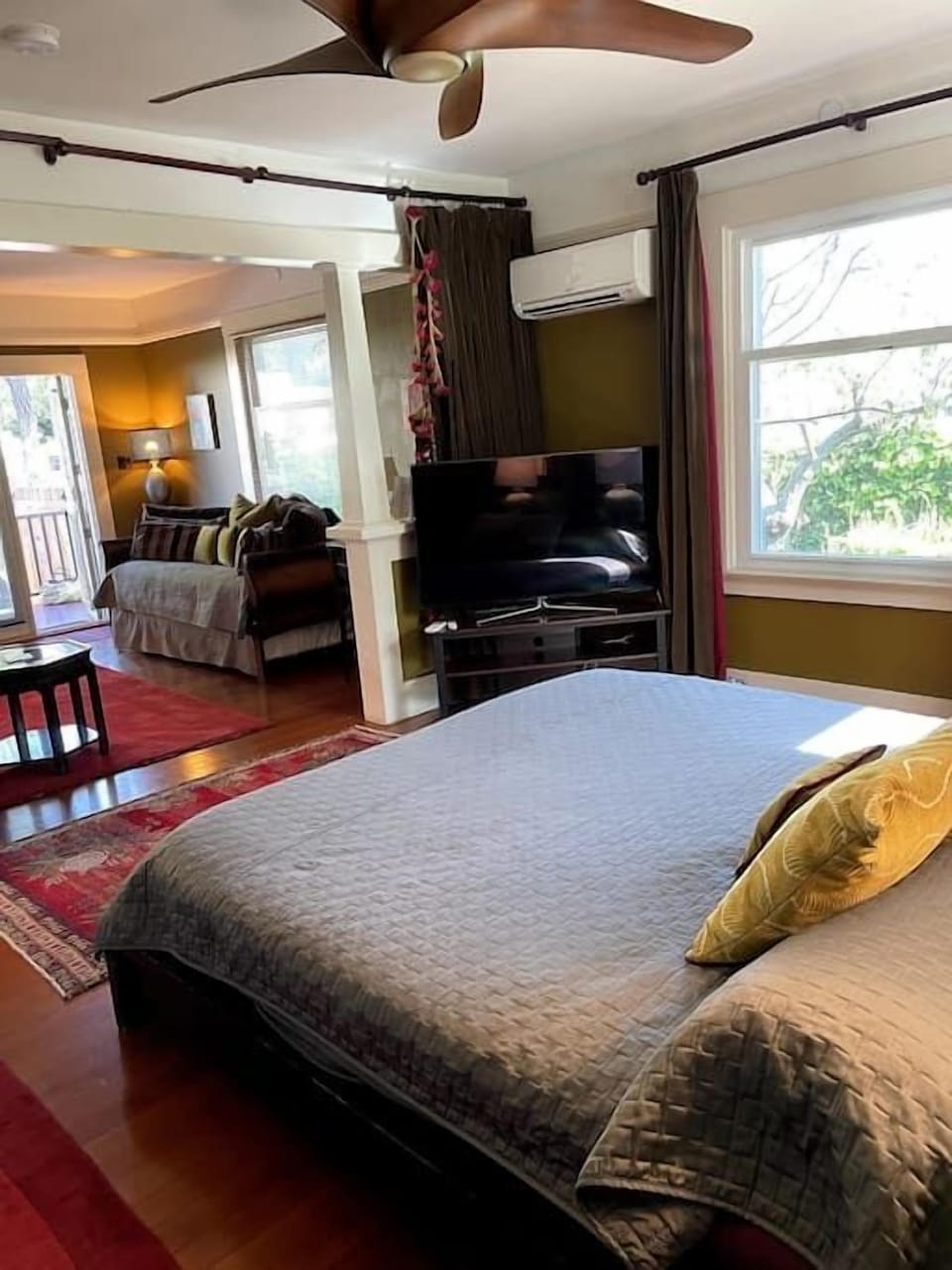 View from bedroom corner facing the trundle bed in living room and apartment entrance from private deck.