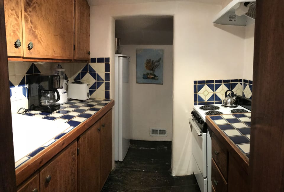 Kitchen features Mexican tiles and stove, fridge, microwave, appliances.