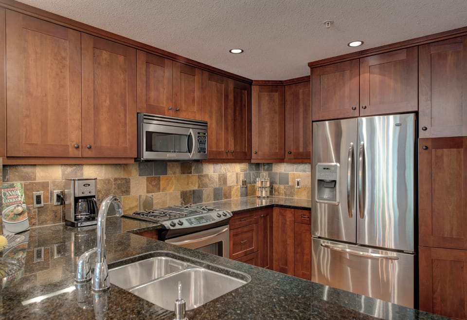 Chefs kitchen with stainless steel appliances and gas range