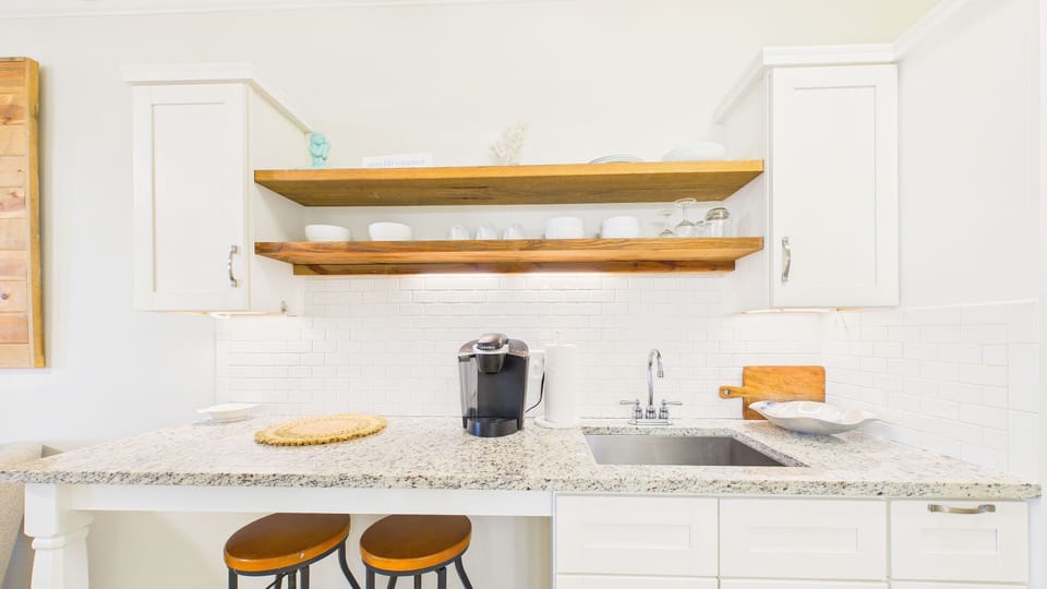 Full kitchenette with coffee essentials and barstool seating