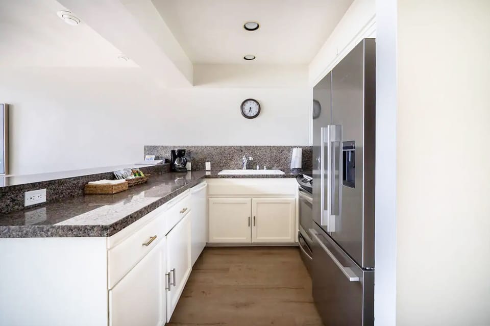 Kitchen includes a stove, microwave, dishwasher, and kitchenware to cook a meal