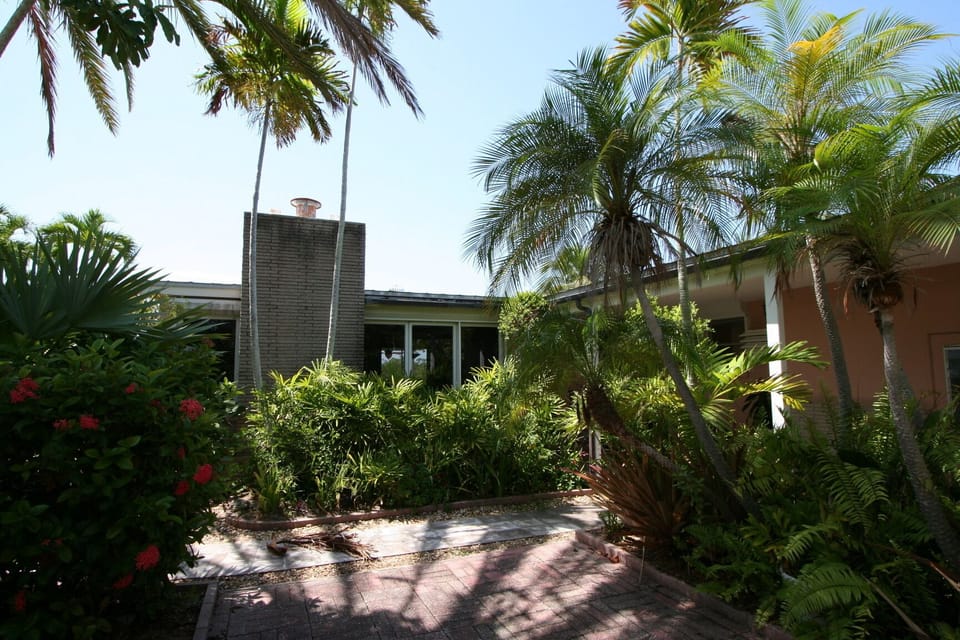 Front of home. Lush tropical foliage throughout property. 