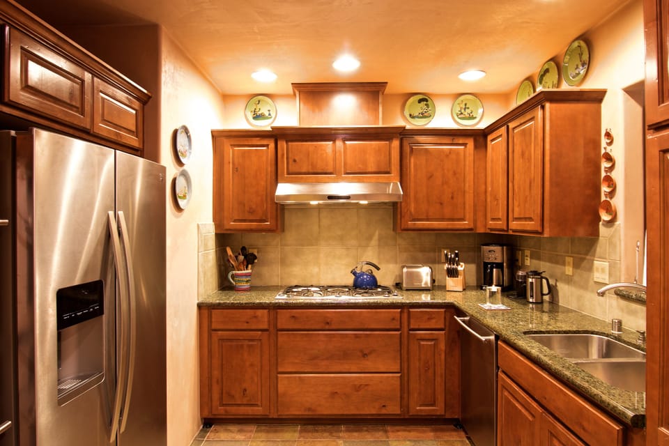 The kitchen includes granite countertops, gourmet equipment, antique pottery. 