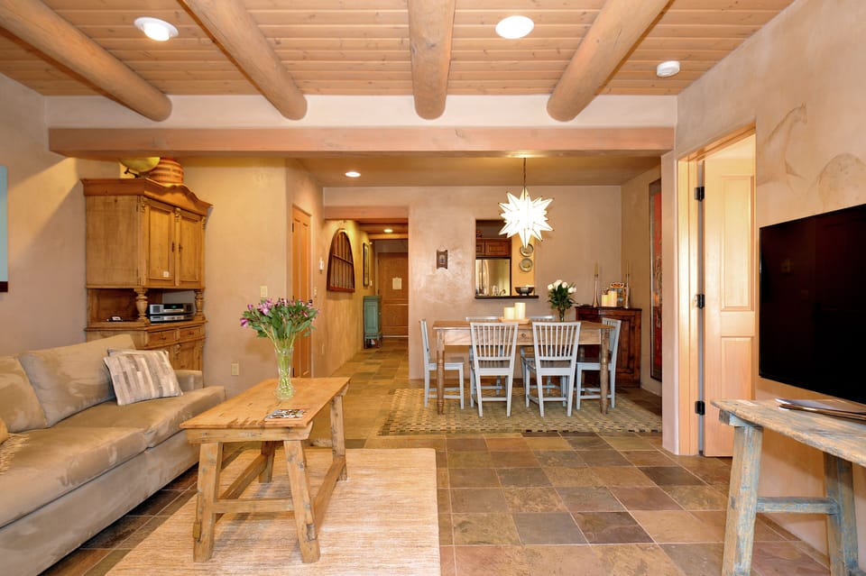 Looking at living room, dining room, and hall, standing in front of patio doors.