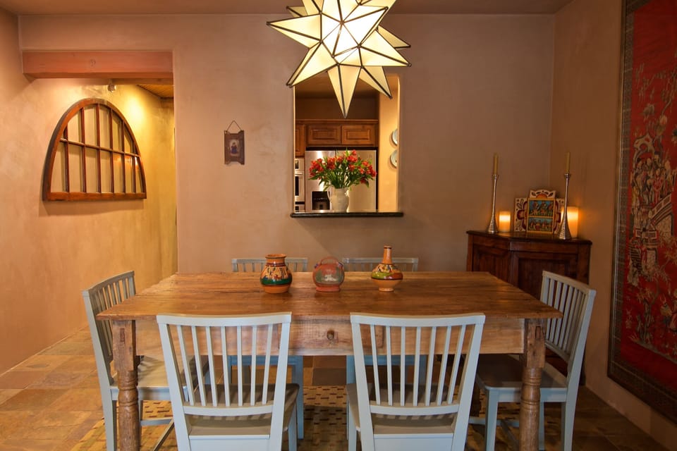 The open living area includes an antique Spanish colonial dining table. 