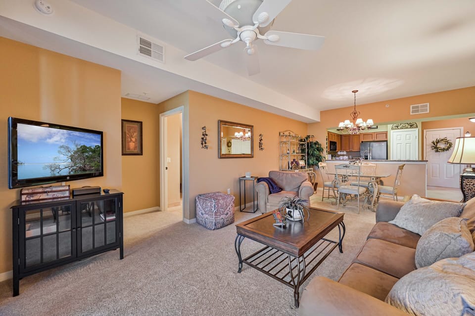 VI103 - The living room is equipped with comfortable seating and a fat screen TV. Sliding doors opening up to the lanai with lake view