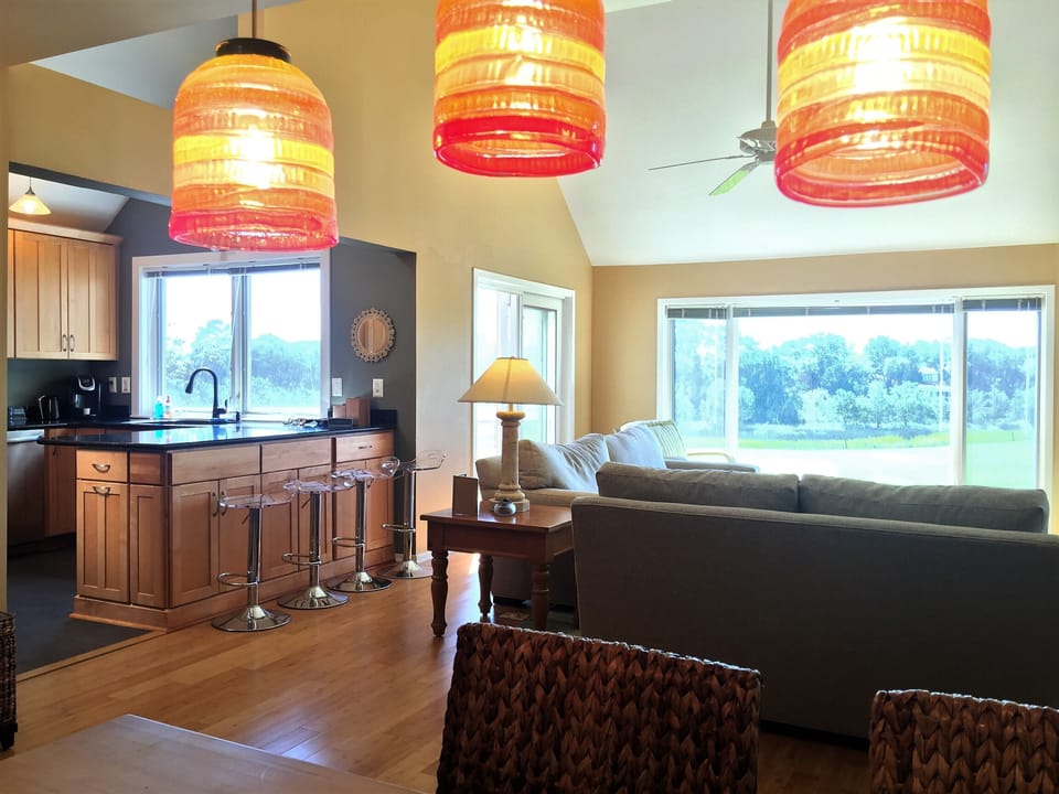 Comfortably furnished living room with walls of glass and bamboo flooring