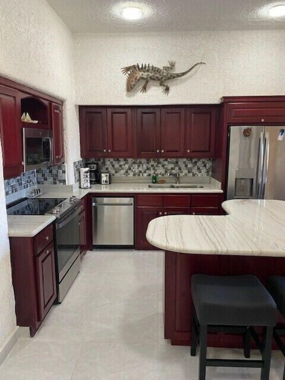 Remodeled kitchen with beautiful marble countertops and island.