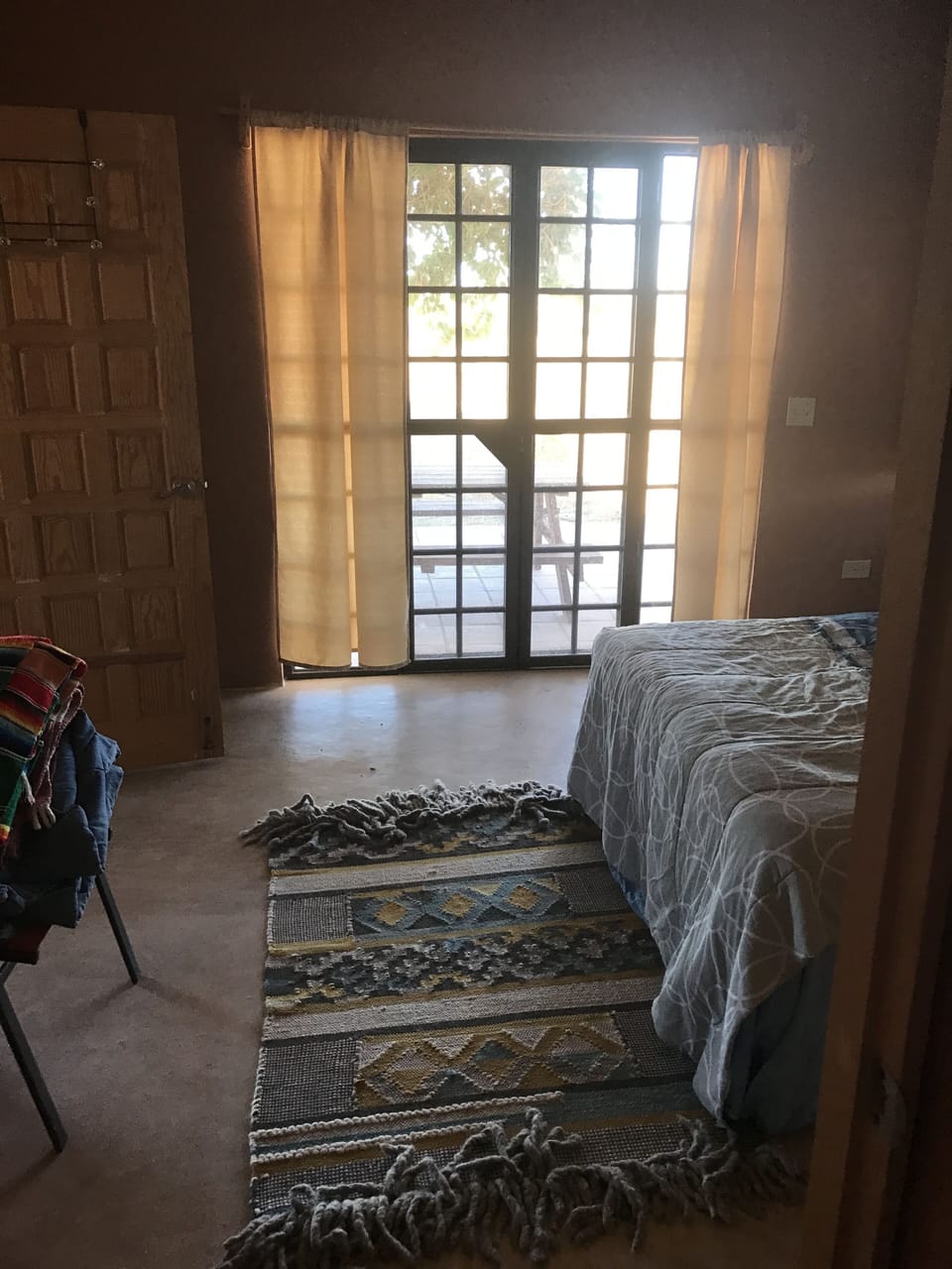 view from bedroom with double doors to pool