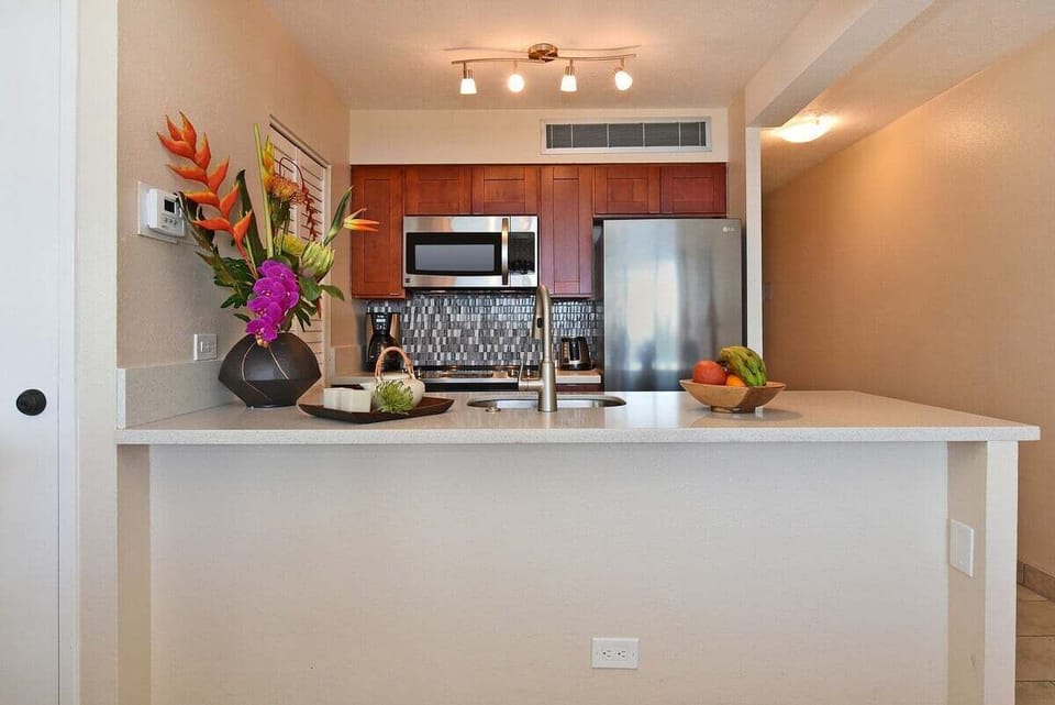 Enjoy cooking in this modern kitchen featuring a large island, sleek finishes, and panoramic views of the sea