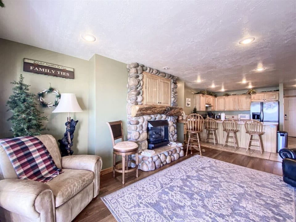 Warm living room with fireplace flowing into open kitchen