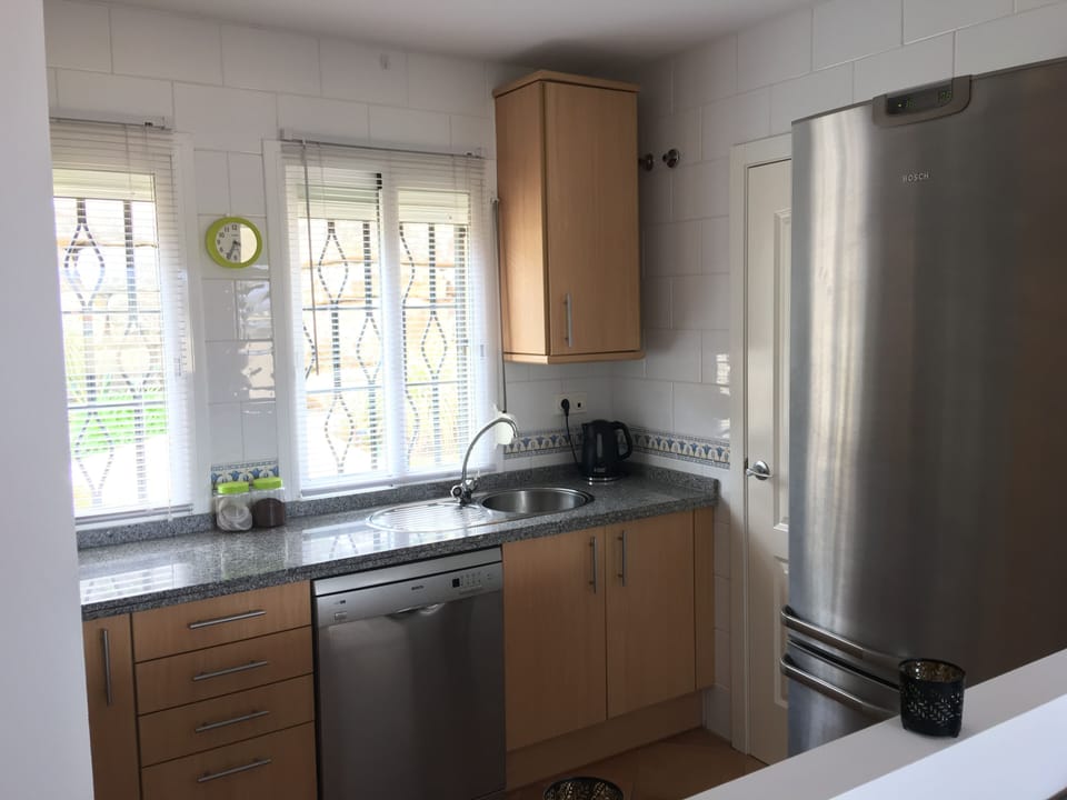 Modern kitchen with dishwasher, huge fridge/freezer, hob/oven, washing machine.