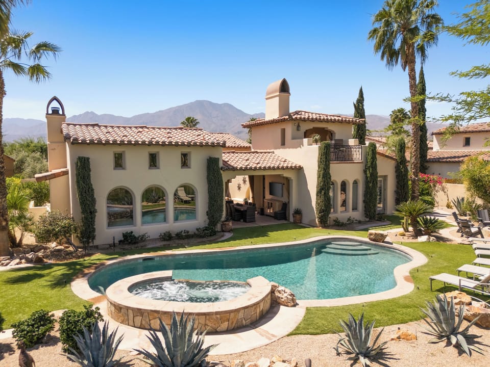 Large Backyard full of amenities such as oversized pool, spa, chaise lounge chairs, fire pit, outdoor kitchen with BBQ, al fresco dining and outdoor TV