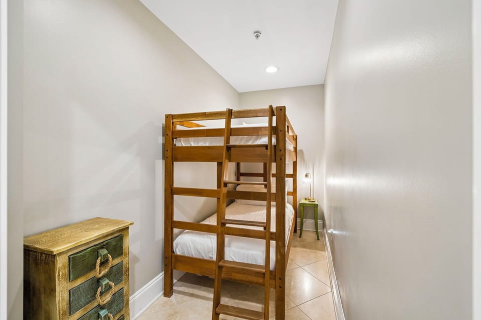 Your kids will love claiming their spot in this cozy bunk room, where sturdy wooden bunks and a cheerful green side table create a playful, restful retreat after a day of adventure.