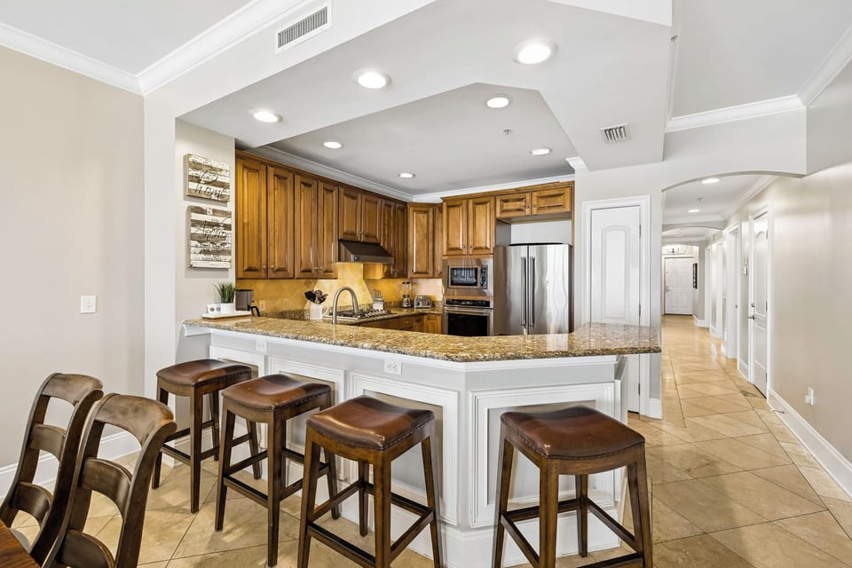 You'll love gathering around this spacious kitchen island with granite countertops and warm wood cabinetry. The fully equipped kitchen makes meal prep a breeze, perfect for your vacation mornings.