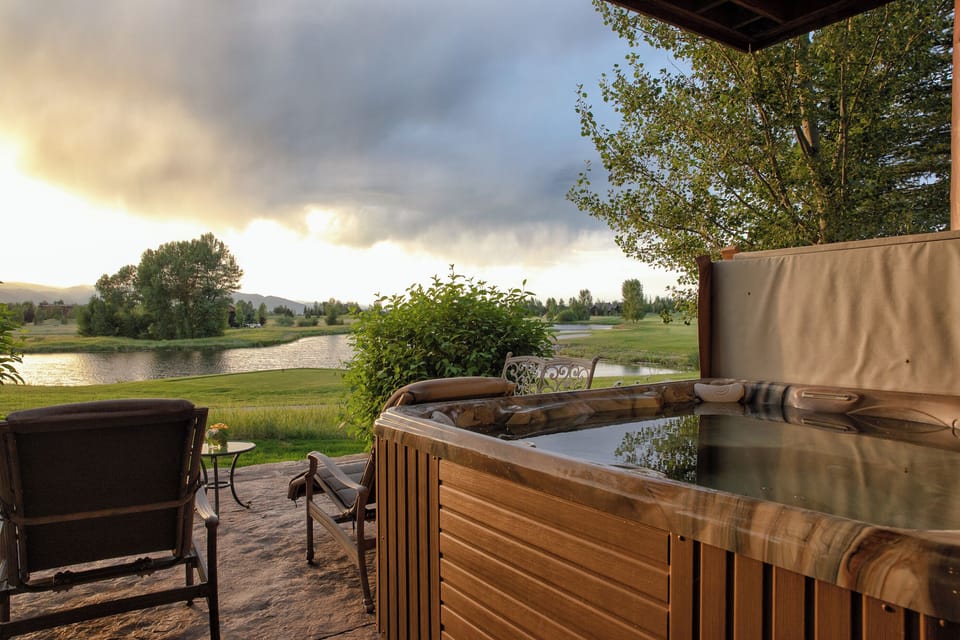 Slip into pure relaxation as you soak in your private hot tub, watching the sunset paint the sky while overlooking pristine lake waters and rolling countryside—your perfect evening sanctuary awaits.