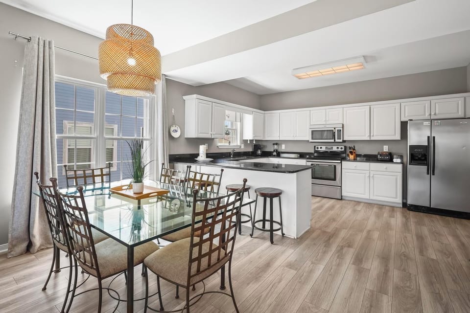 Kitchen/Dining - The fully stocked kitchen features seating for 4 at the open bar, and a table is provided in the dining area with seating for 6.