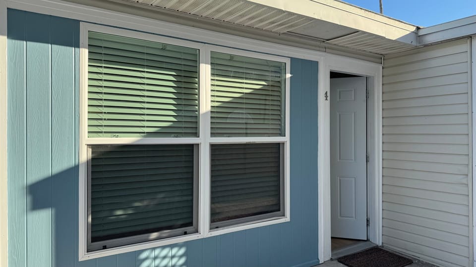 Exterior of the property featuring private entrance and large windows.