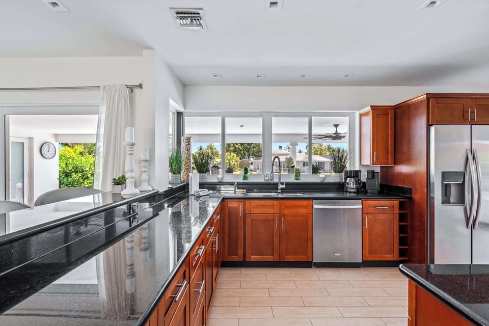 The kitchen is large and modern with windows that open up to the pool area