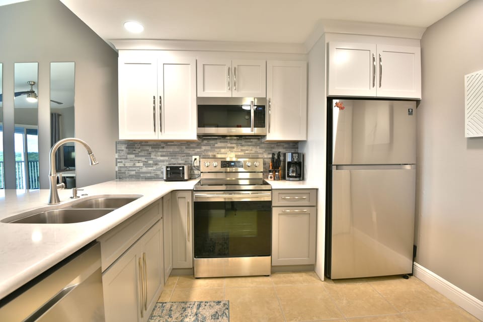 Kitchen with stainless refrigerator, sink, and updated cabinetry