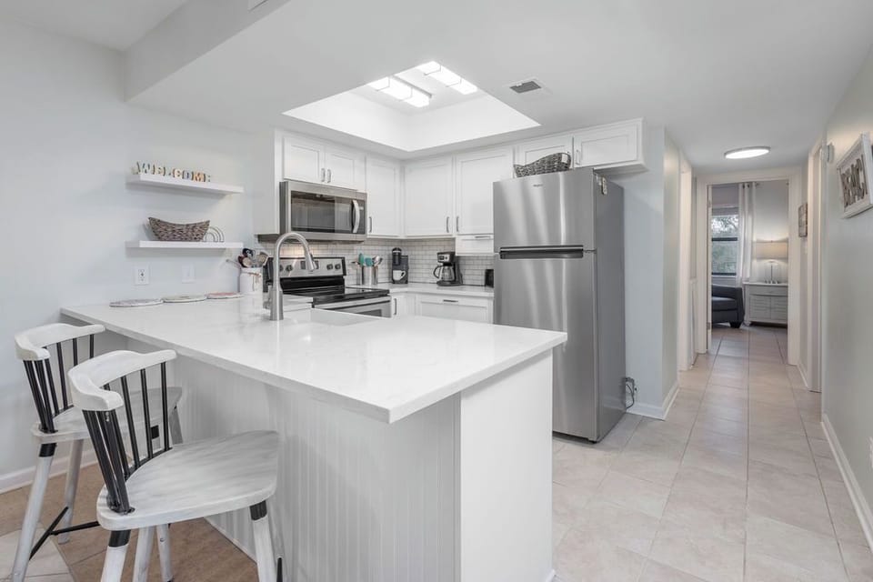 Kitchen - Equipped kitchen with stainless steel appliances - including a dishwasher, smooth cooktop, electric stove, built-in microwave, and refrigerator with ice maker - this kitchen is fully stocked with all the essentials for meal prep, making it perfect for entertaining or cozy nights in.