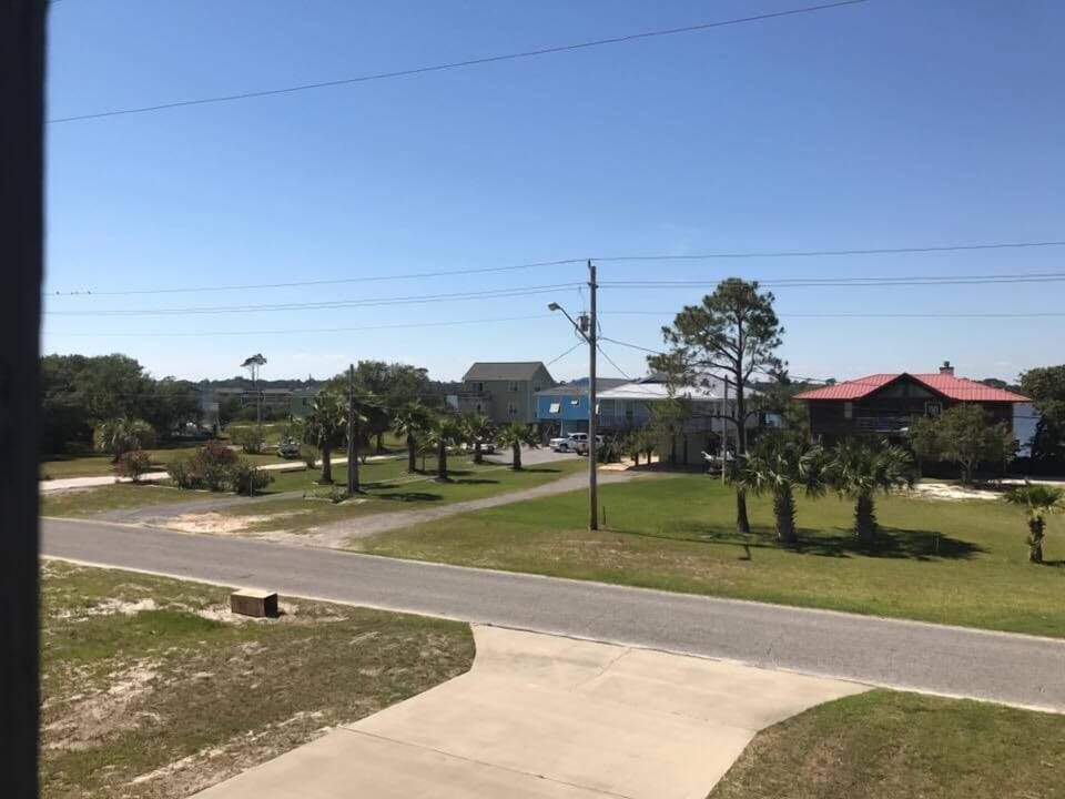 North View - The large balcony accessed from the living area, primary bedroom, and guest bedroom, offers peek a boo views of Little Lagoon.