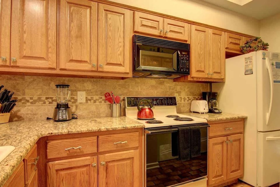 The full kitchen comes fully stocked with utensils, pots, pans, bowls, and plates. 
