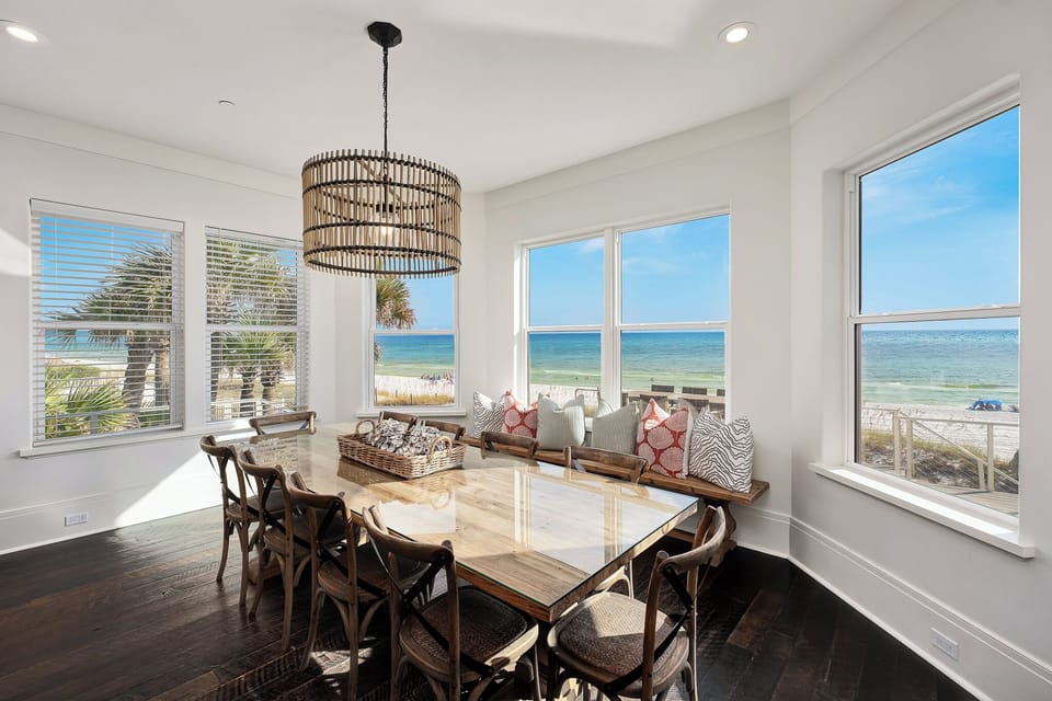 Your dining space frames stunning ocean views through floor-to-ceiling windows, creating the perfect backdrop for memorable meals together.