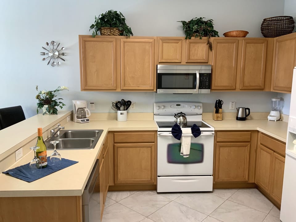 Kitchen with coffee maker, kettle, toaster, blender, microwave, dishwasher.