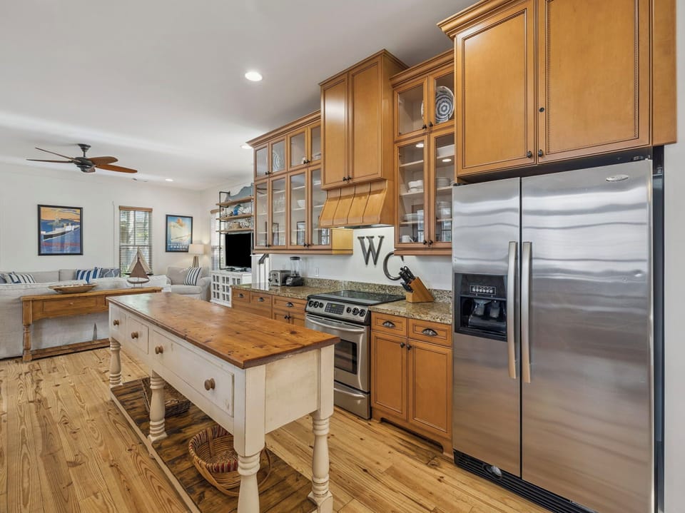 Step into your gourmet kitchen featuring warm wood cabinets, granite counters, and stainless appliances—perfect for creating memorable meals together.