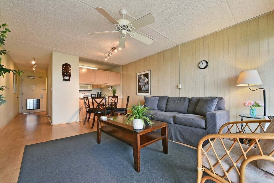 Bright living room with sleeper sofa, dining table, and tropical light.
