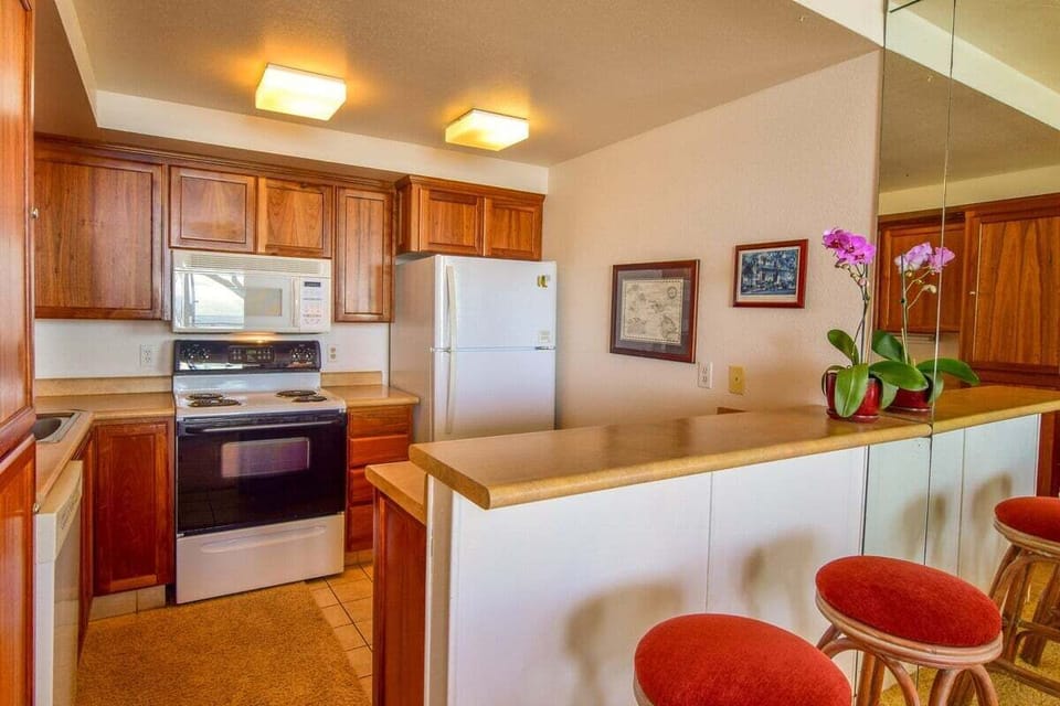 Bright and practical kitchen space complete with full-size appliances and a cozy bar area for effortless meals and morning coffee