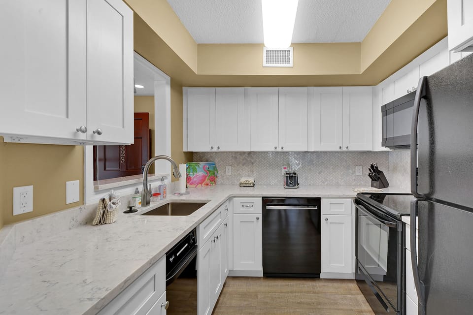 Kitchen with Stainless Appliances - Stone counters, full-size appliances, and prep space support easy meals during the stay.