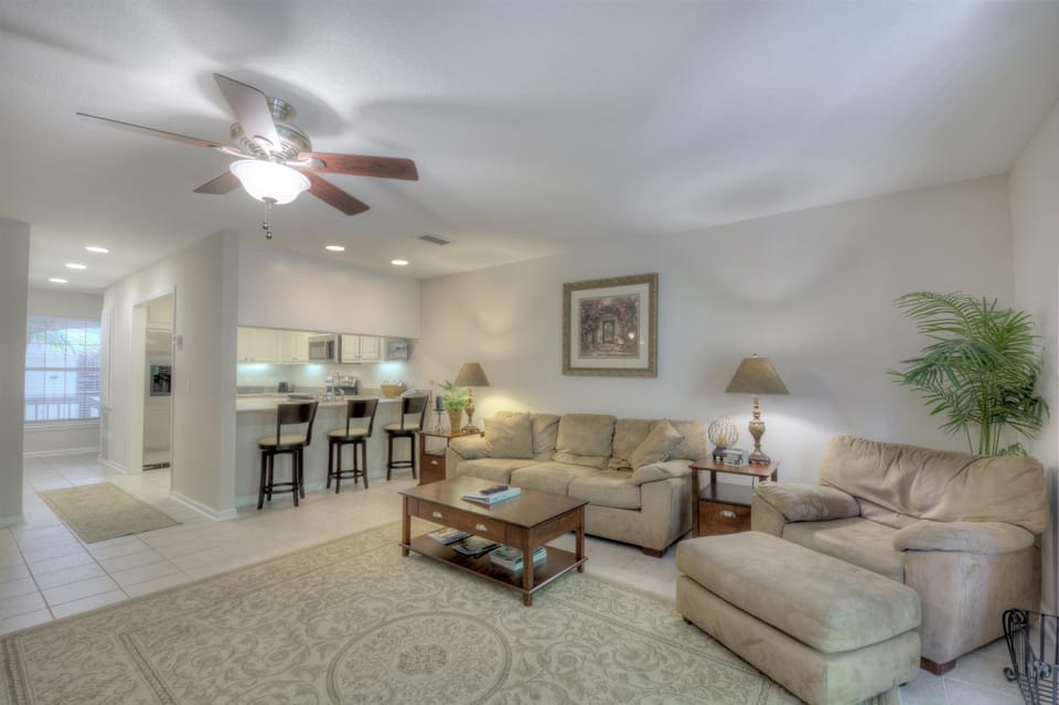 Living Room – Bright, Airy Comfort Near St. Simons Beaches - Spacious and sunlit, this open-concept living room offers the perfect place to unwind after exploring St. Simons Island. Coastal tones, plush seating, and direct sightlines to the kitchen make it ideal for gathering with family or friends just minutes from the beach.