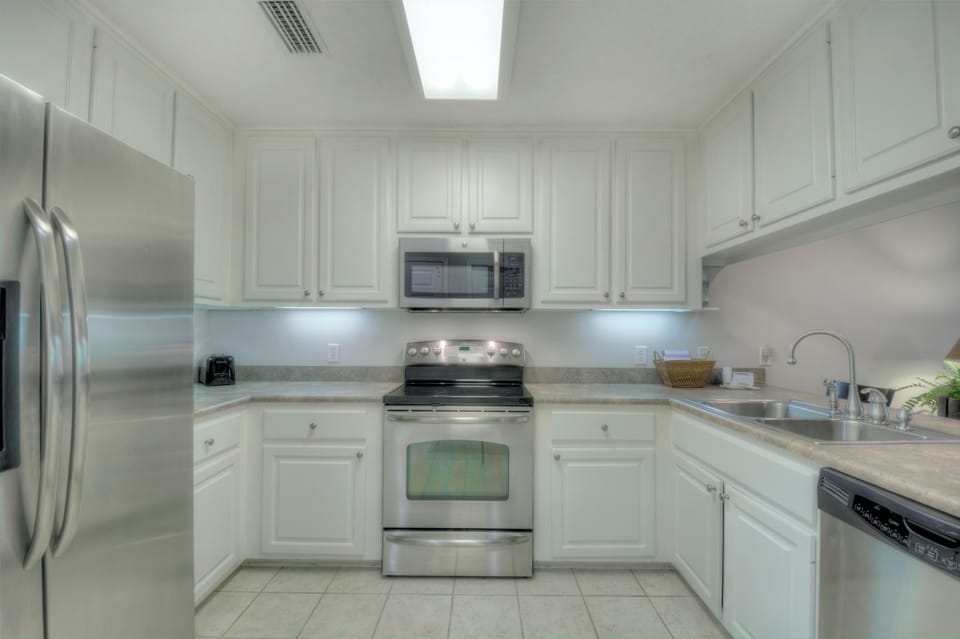 Kitchen with Stainless Appliances - White cabinets, range, microwave, dishwasher, and full-size refrigerator support easy meals.