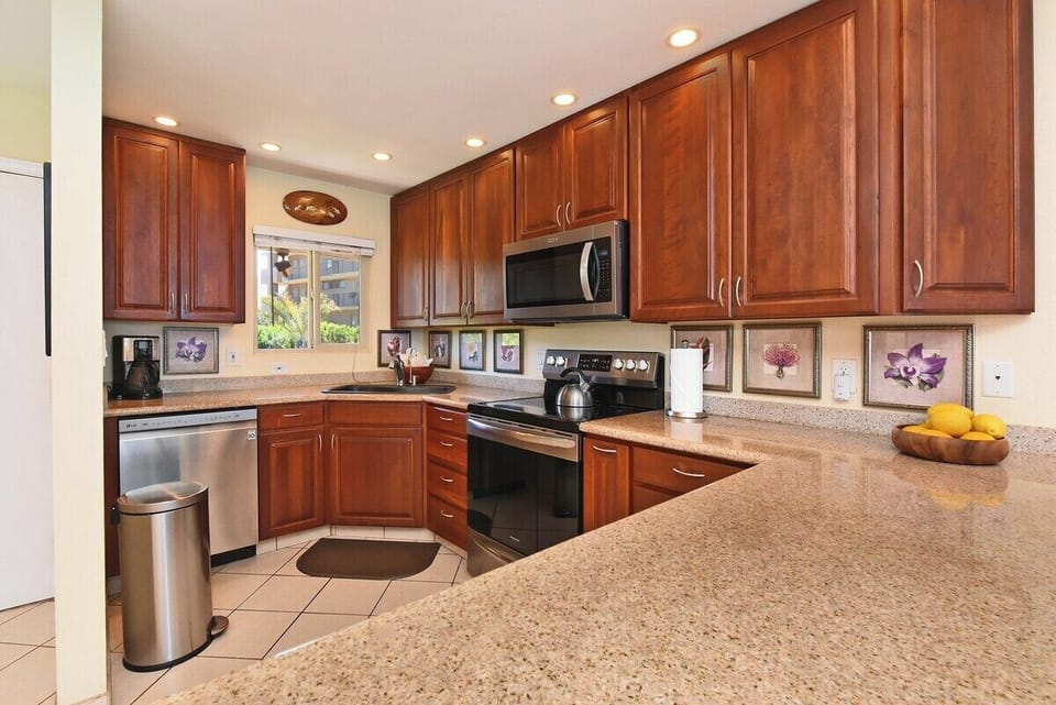 Modern, fully stocked kitchen with stainless‑steel appliances, rich wood cabinetry, and plenty of counter space for meal prep