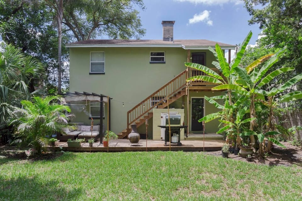Outdoor Oasis: Enjoy sunny days on the deck surrounded by lush greenery and a BBQ grill!