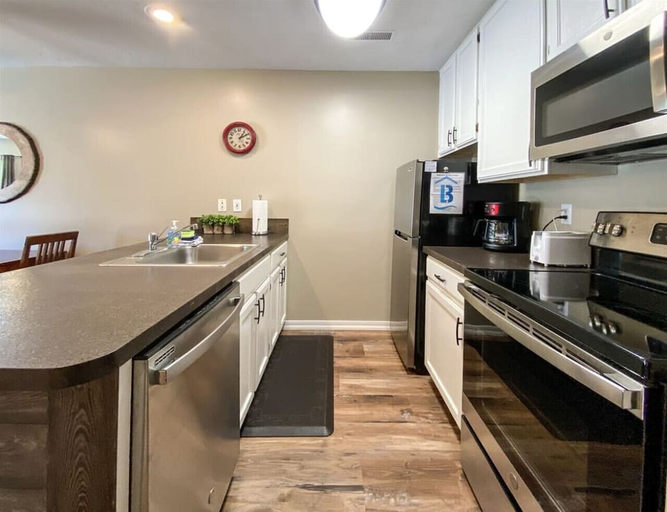 Modern kitchen with stainless steel appliances and cozy seating, perfect for cooking and gathering together.