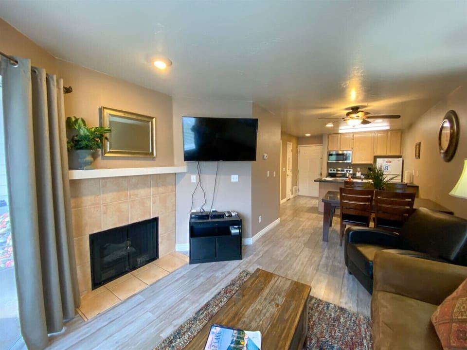 Cozy living space with fireplace, TV, and open kitchen—perfect for relaxing and entertaining.