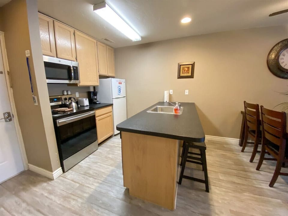 Spacious kitchen with modern appliances and bar, perfect for enjoying morning coffee or meals