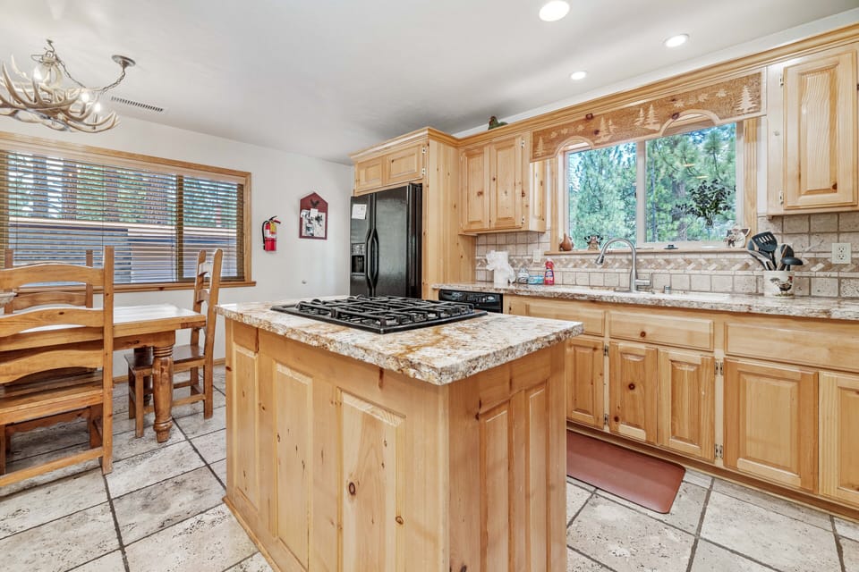 Kitchen - This kitchen is spacious for dining, cooking, & gathering! Beautiful Marble Countertops throughout with pine wood cabinets and a dining table that seats 6 with additional bar seating for 4 people. All cooking & eating necessities are supplied.