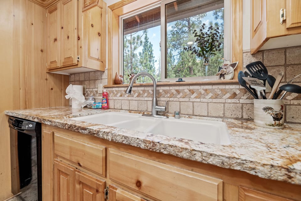 Kitchen - This kitchen is spacious for dining, cooking, & gathering! Beautiful Marble Countertops throughout with pine wood cabinets and a dining table that seats 6 with additional bar seating for 4 people. All cooking & eating necessities are supplied.
