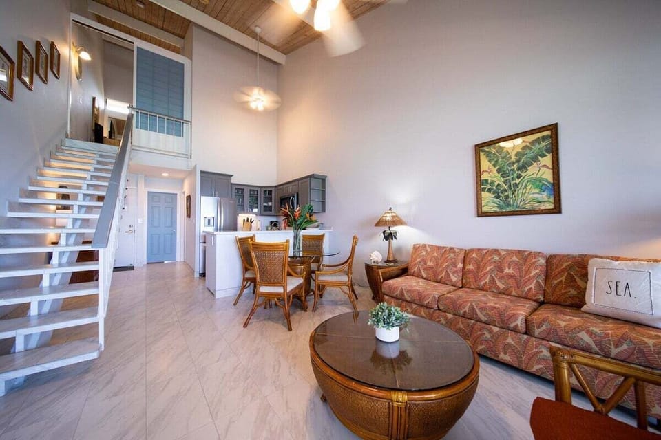 Bright living room with ocean views, cozy seating, and indoor-outdoor flow to lanai.