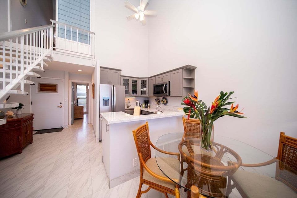 Dining area with seating for four, adjacent to living space and kitchen.