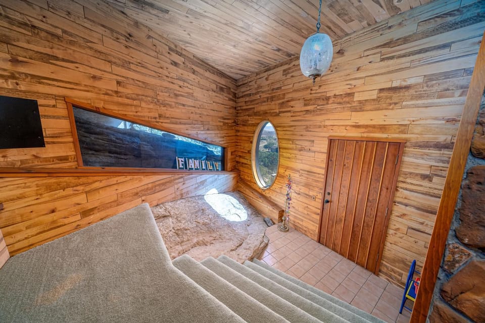Behind fireplace. Exposed slab top part of rock downstairs. 
